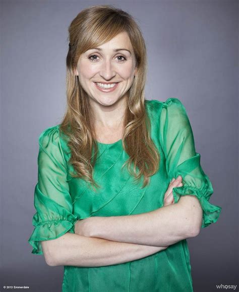 A Smiling Woman In A Green Dress With Her Arms Crossed