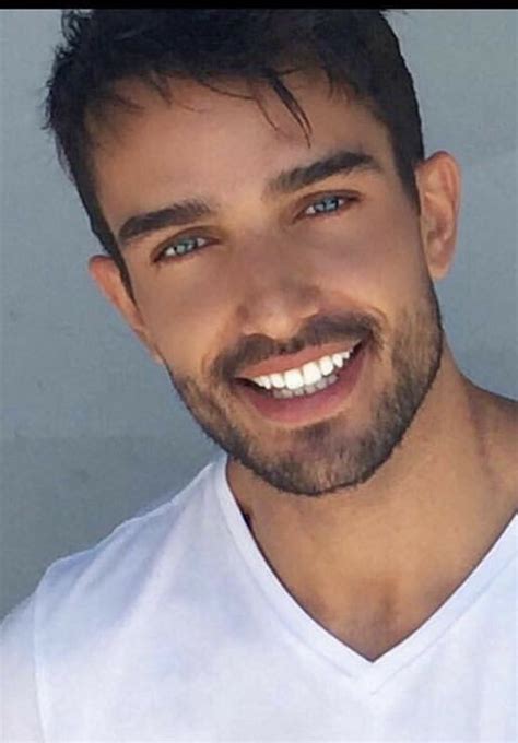 A Close Up Of A Person Wearing A White T Shirt And Smiling At The Camera