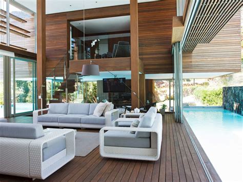 A Living Room Filled With White Furniture Next To A Swimming Pool On