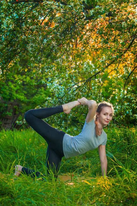 beautiful woman doing yoga outdoors on green grass stock image image of padahastasana bend