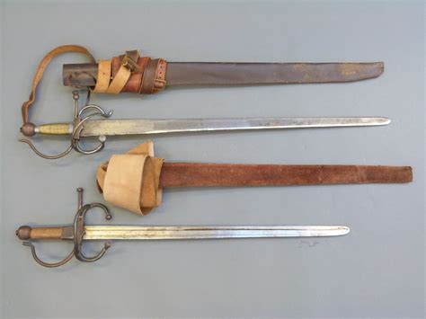A Pair Of Replica English Civil War Swords With Leather Scabbards And