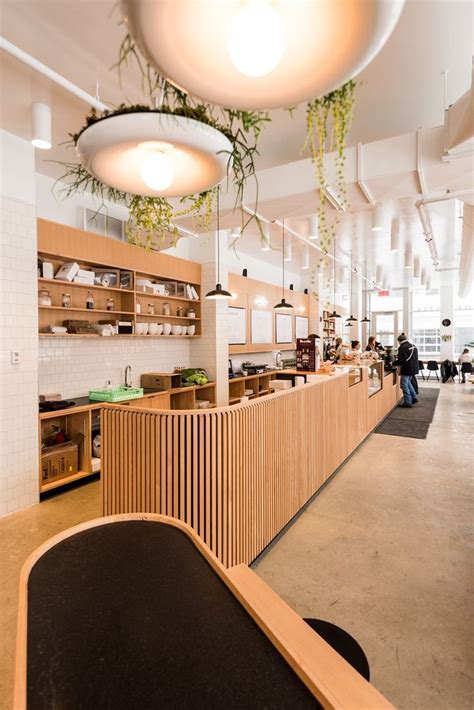 A Restaurant With Wooden Counters And Plants Hanging From The Ceiling