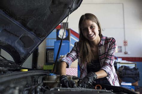 Young Casual Woman Smiling At Camera While Fixing Car Engine And