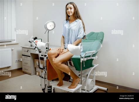 Woman Sitting On The Gynecological Chair Before A Medical Examination By A Gynecologist In The