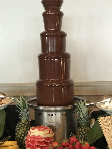 A Chocolate Fountain With Strawberries Pineapples And Other Fruit On