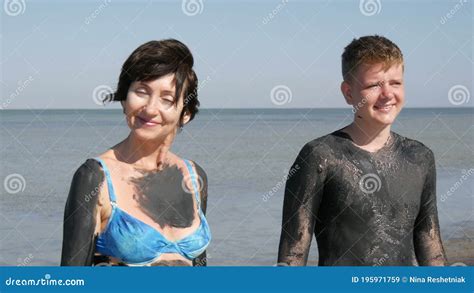 Oiled Up Mom And Teen Son Smile Healing Black Medical Mud At The Lake Of Salt Water Salty Black