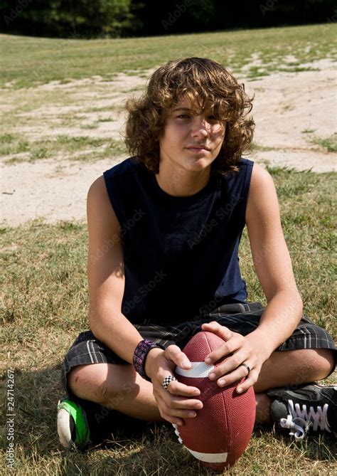 Boy With Long Curly Hair Sitting With Football Stock Photo Adobe Stock
