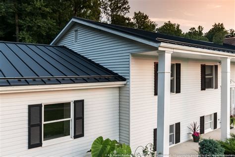 White House With Textured Black Standing Seam Midcentury Exterior