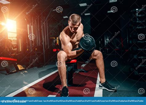 professional bodybuilder bodybuilder sitting on a bench doing exercises with dumbbells in the