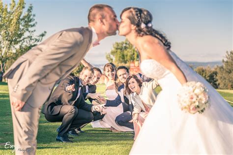 A Bride And Groom Kissing In Front Of Their Wedding Party