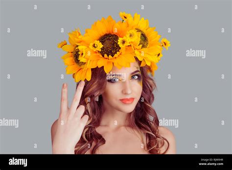 attractive woman with floral headband is showing peace victory sign smiling looking at the