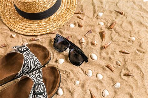 Summer Beachwear Flip Flops Hat Sunglasses And Seashells On Sand