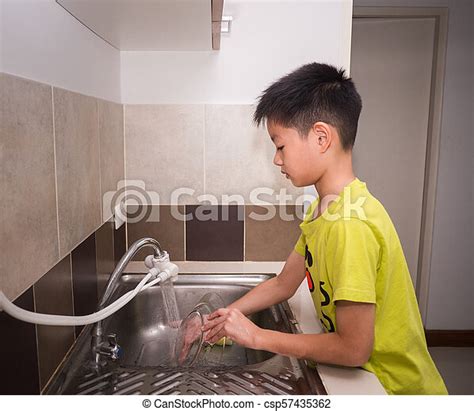Adorable Kid Boy Washing Dishes In Domestic Kitchen Child Having Fun