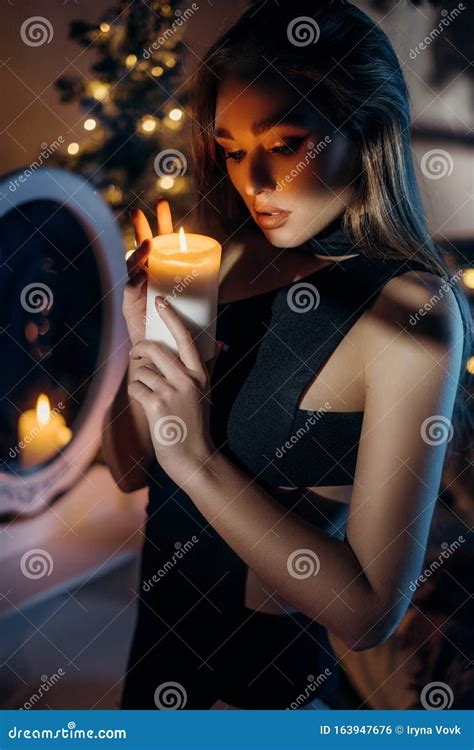 Beautiful Woman Holding A Burning Candle In Her Hands Stock Photo