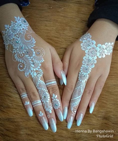 Two Hands With White Henna Designs On Them