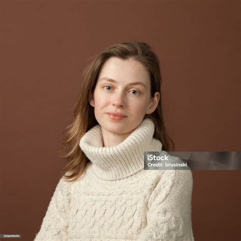 Studio Portrait Of A 30 Year Old Woman On Brown Background Stock Photo