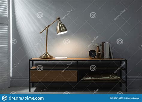 Stylish Lamp Clock And Books On Wooden Cabinet Indoors Interior