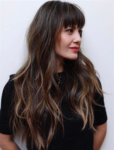 Long feathered cut with razored bangs long layered hair is beautiful on. Picture Of a long layered haircut with balayage and eyebrow skimming bangs for an effortless look