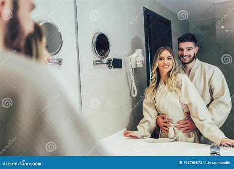 Couple In Front Of The Mirror While Getting Ready In The Bathroom Stock