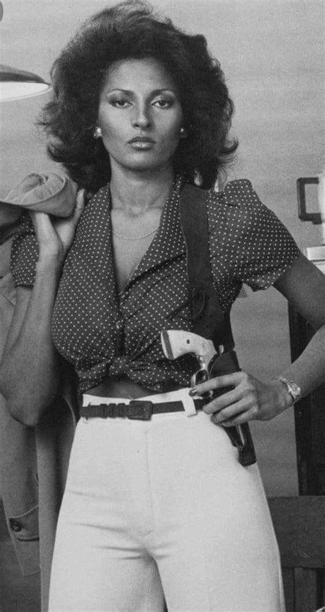 an old photo of a woman in white pants and polka dot shirt standing with her hands on her hips