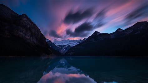 Snow Capped Mountains Under Black Light Purple Clouds Blue Sky