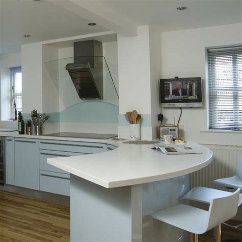 Breakfast bars are a fantastic way to economise on space for smaller kitchens, but work equally well alongside a larger kitchen table. A breakfast bar encloses this white and pale blue kitchen ...