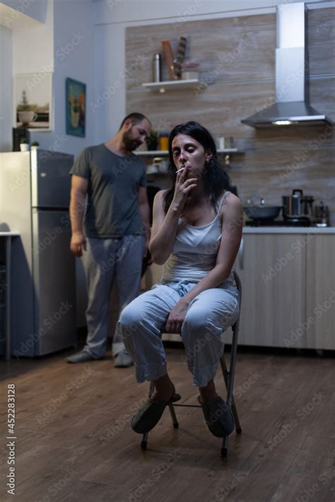 Zdjęcie Stock Unhappy Terrified Woman Sitting And Smoking Cigarette