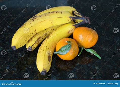 Several Bananas And Two Mandarin Oranges Stock Photo Image Of