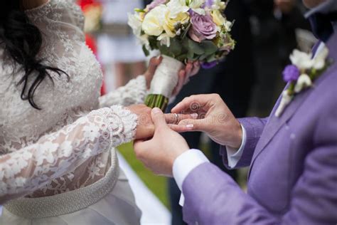 Handsome Groom Putting On Ring On Bride At Wedding Aisle Closeup Stock