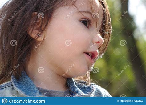Closeup Portrait Of Little Cute Emotional Girl With Pigtails In A Denim