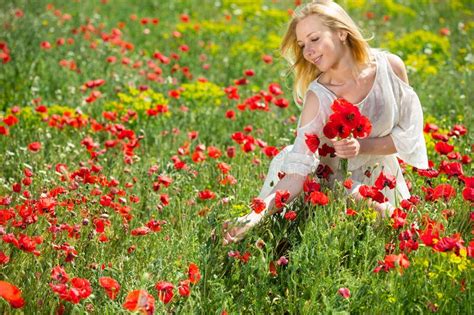 Young Girl In White Dress Picking Poppies Plants Outdoor In Fields
