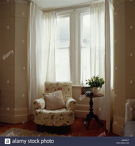 Is your favorite color toile? Patterned cream armchair in front of bay window with white ...