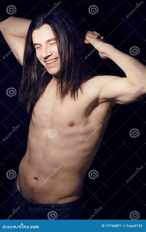 Hübscher Junger Mann Mit Dem Nackten Torso Des Langen Haares Auf Schwarzem Hintergrund Lächelnd