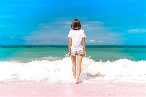 Young Woman Haveing Fun With Ocean Waves On A Tropical Beach Of Image