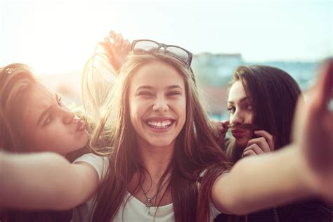 Group Of Smiling Girls Taking Funny Selfie Outdoors At Sunset Boley Braces