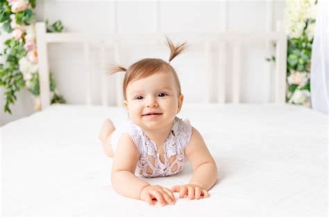 Premium Photo Smiley Baby Girl Sitting On The Bed