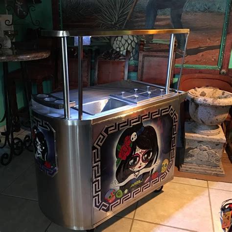 A Stainless Steel Food Cart Sitting On Top Of A Tile Floor Next To A