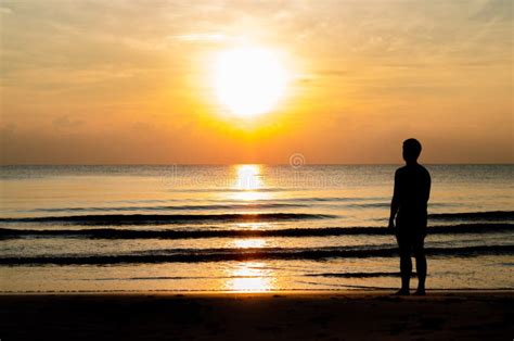 The Silhouette Photo Of A Man Standing Alone On The Beach Enjoy Sunrise