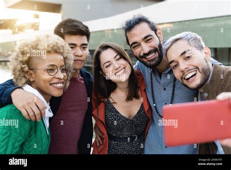 Young Multiracial People Having Fun Doing Selfie With Mobile Phone Outdoor In The City Focus