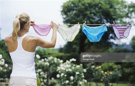 Rear View Of A Young Woman Hanging Undergarments On A Clothesline Photo