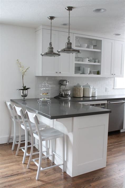 The kitchen cabinets uses a plain polished solid surface countertop in black for a clean, seamless look, combined with white subway tiles for a modern vintage look. 17 Elegant L shaped kitchen design Ideas To Try | Interior God