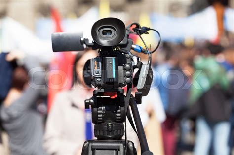 Filming Female Reporter With A Video Camera Blurred Crowd In The