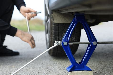 Man Changing Car Tire Focus On Scissor Jack Outdoors Stock Photo Image Of Puncture Hands