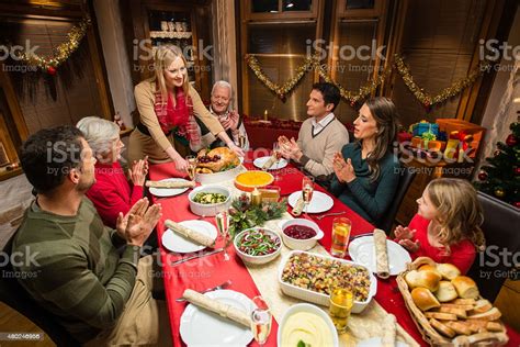 Cooking with the kids at christmas is a really fun family activity. Family Having Christmas Dinner Stock Photo - Download Image Now - iStock