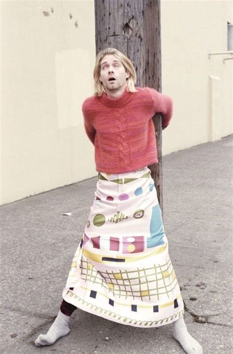 A Woman Leaning On A Telephone Pole Wearing A Colorful Skirt
