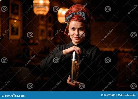 cute redhead bartender girl with dreadlocks standing in the bar with a steel shaker stock image