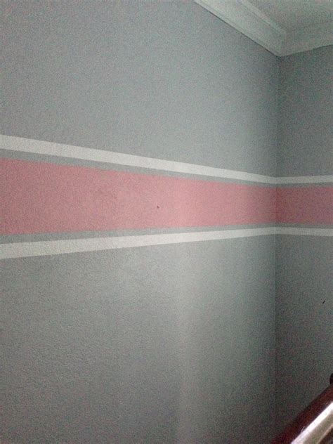 Ecru walls and white bedding let the upholstered headboard stand out with its stylized botanical pattern in blush pink and gray. Grey with pink and white striped walls #babygirl one bold ...