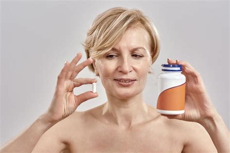 Portrait Of Middle Aged Caucasian Woman Holding A Bottle With Pills And