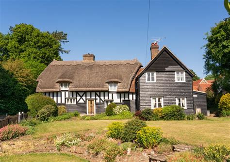 British English Country Cottage With Thatched Roof And Cottage Garden