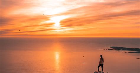 Man Standing On Cliff During Sunset · Free Stock Photo